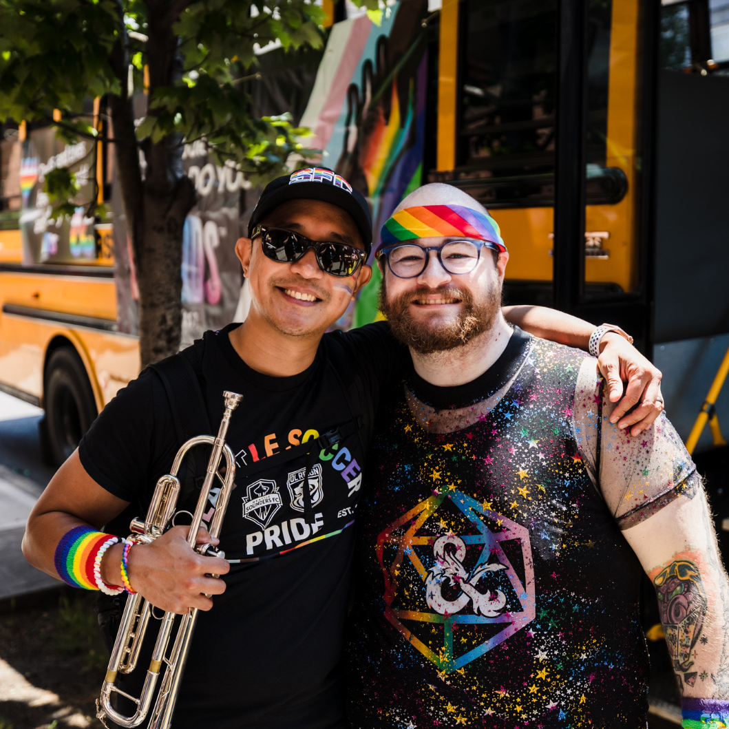 Carl works for Wizards of the Coast and plays trumpet with Seattle Soundwave. Carl with one of his best friends at Pride